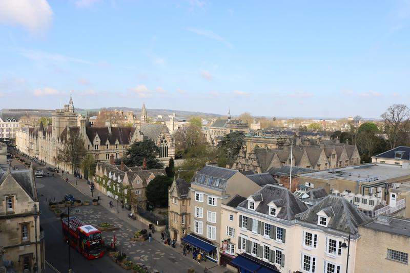 A view of Broad Street Oxford from the Sheldonian Theatre's cupola, with fields and hills in the background